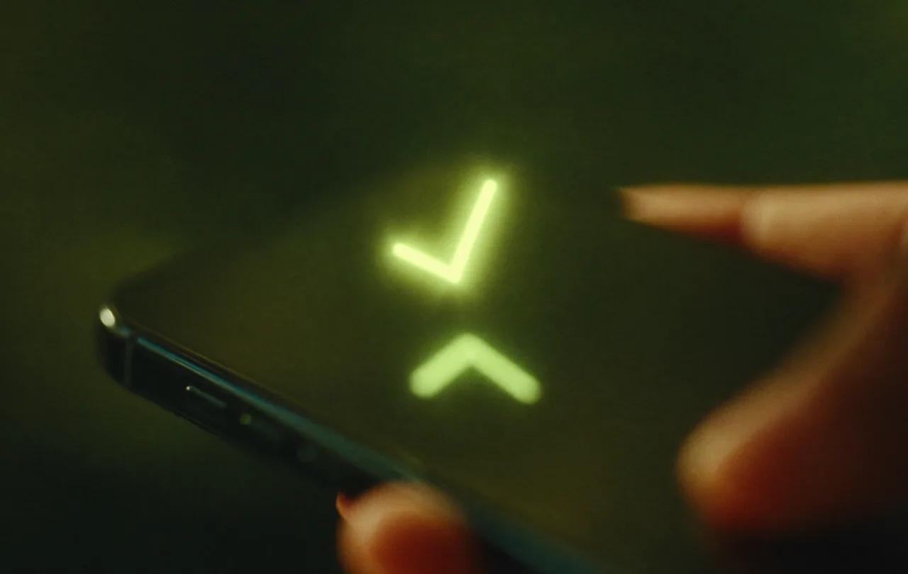 Tela de celular com um check verde iluminado, indicando pagamento confirmado